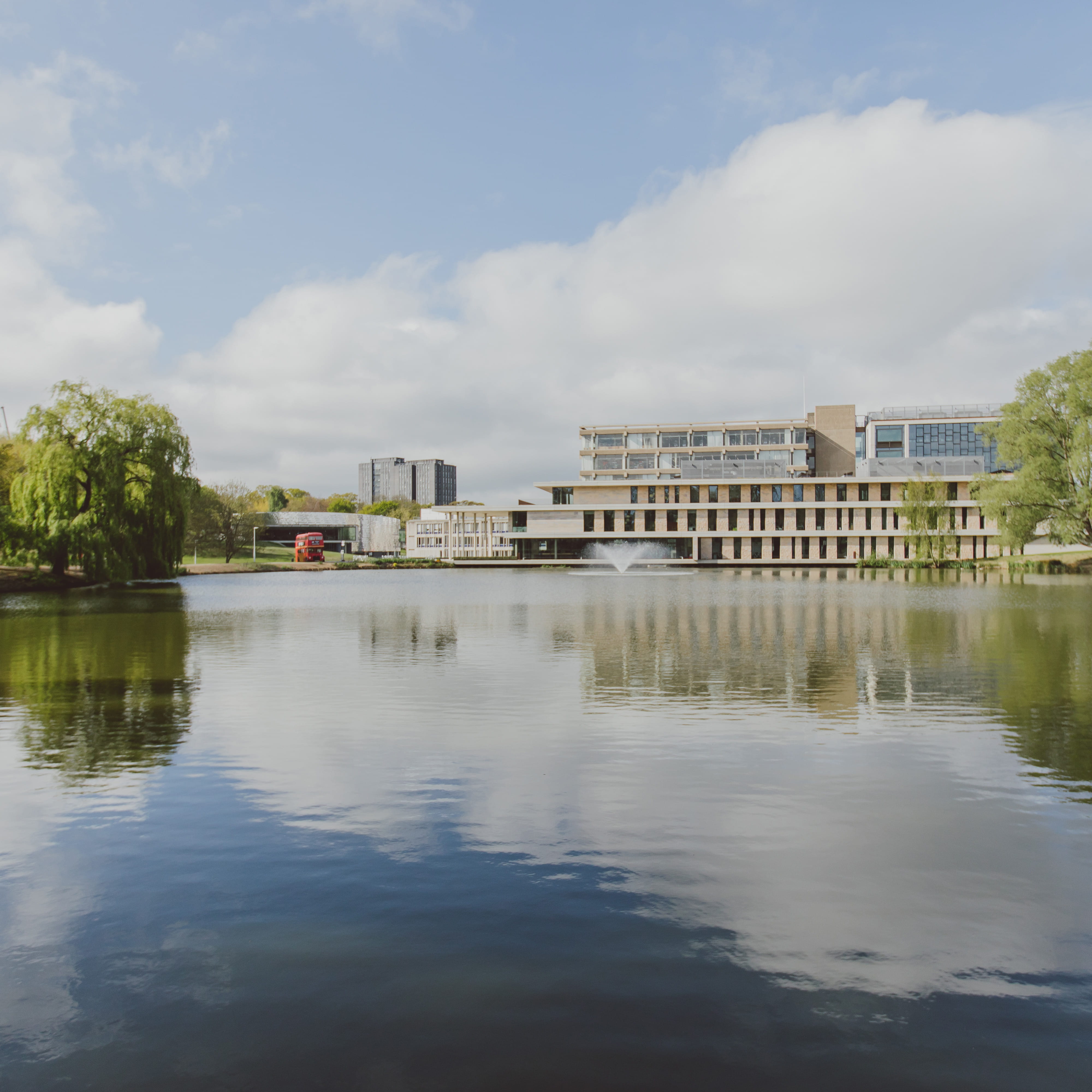 View of the Albert Sloman Library at the University of Essex, from across the grounds and the lake on a sunny day.