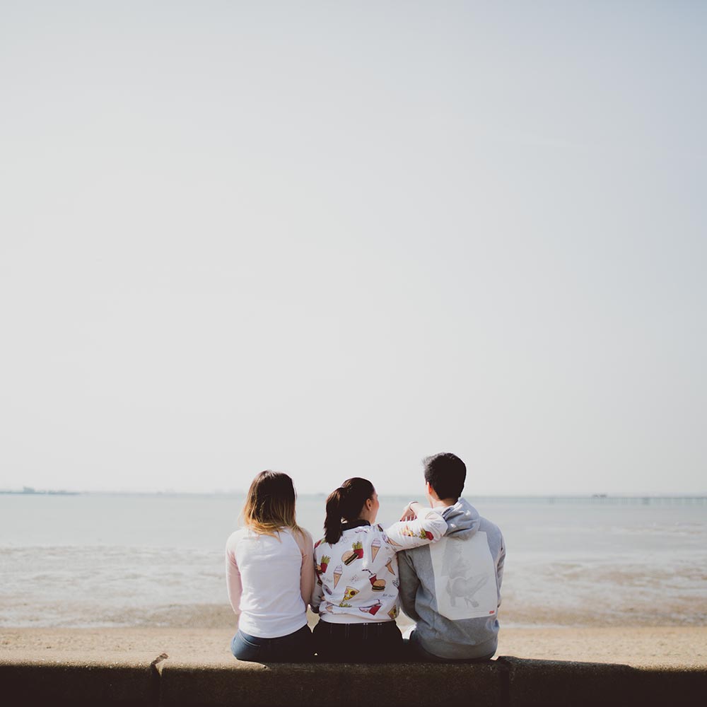students sitting on Southend beach looking at the sea