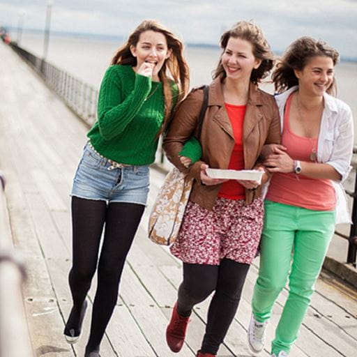 3 female students walk along Southend Pier