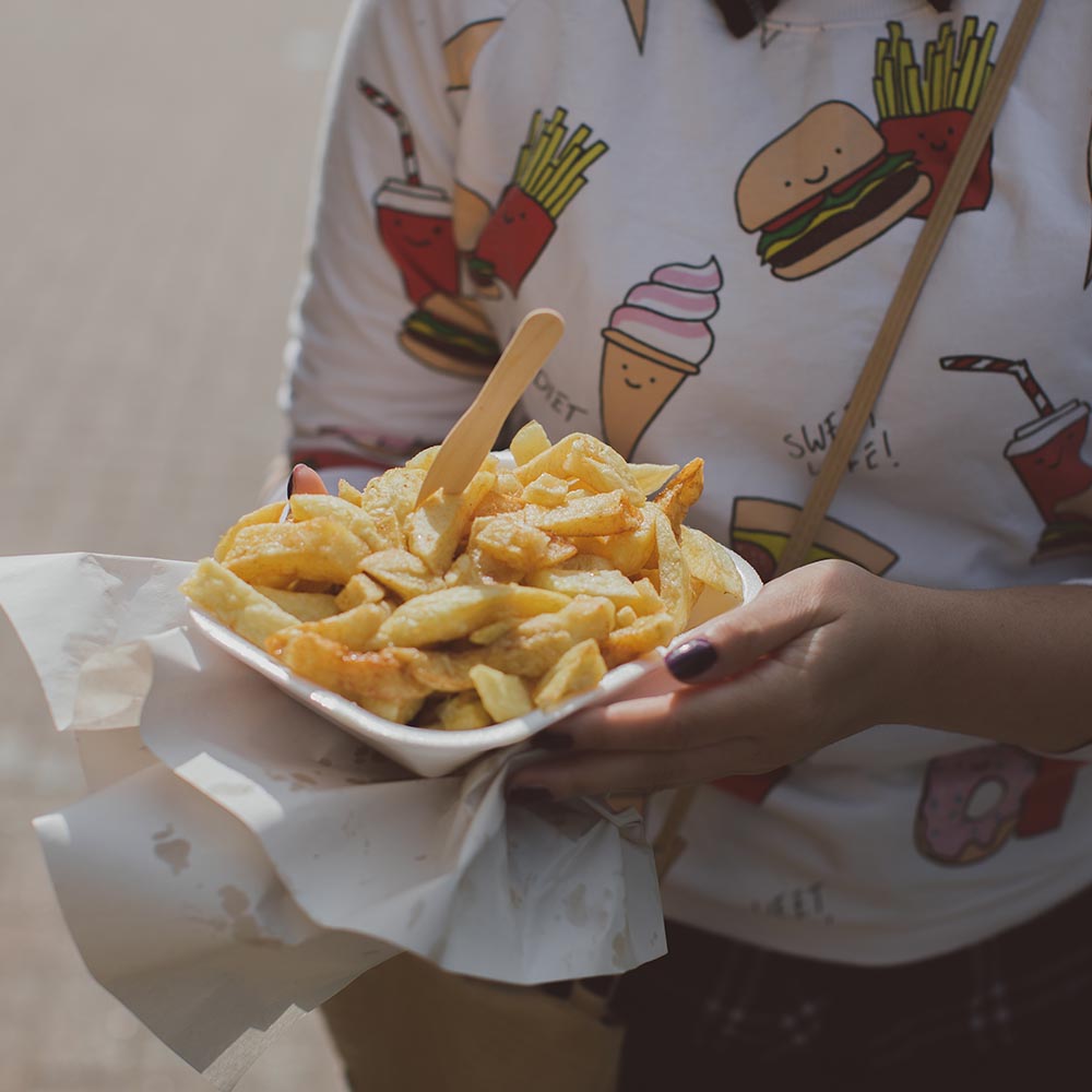 Student eating chips on Southend beach