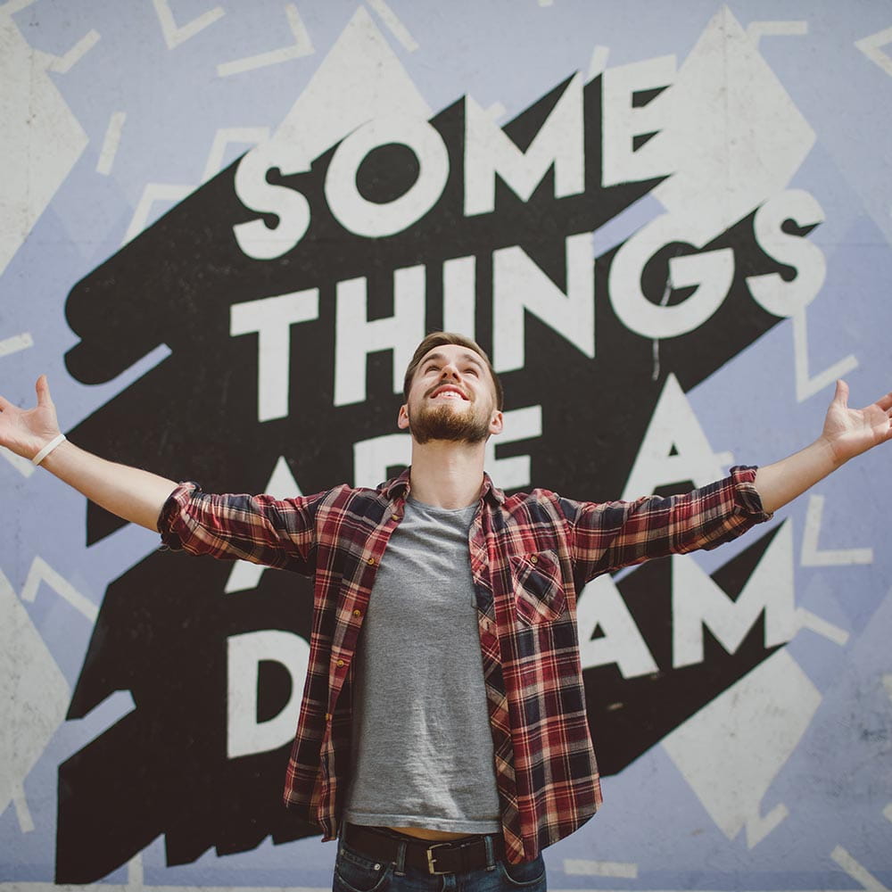 Student in Southend in front of sign saying Some things are a Dream