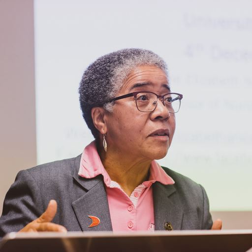 A head and shoulders photo of Dame Professor Anionwu delivering a talk at the University of Essex