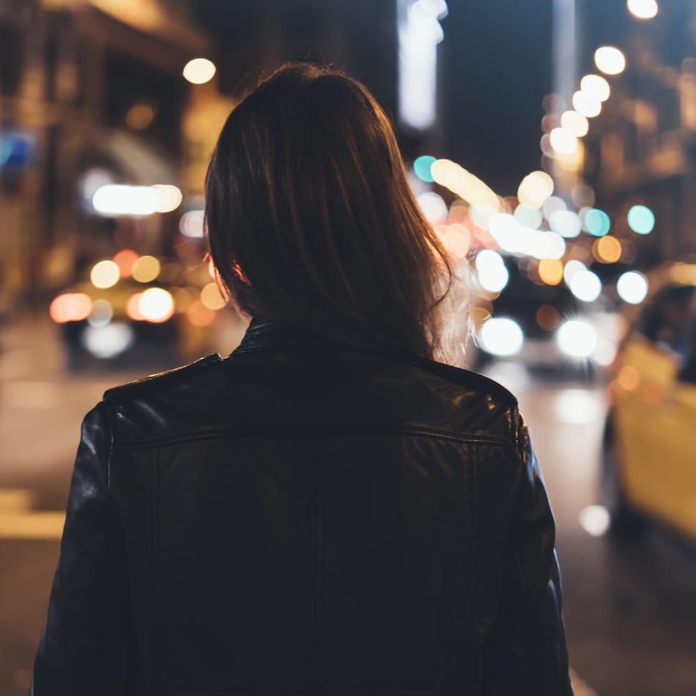 Woman walking on a city street at night