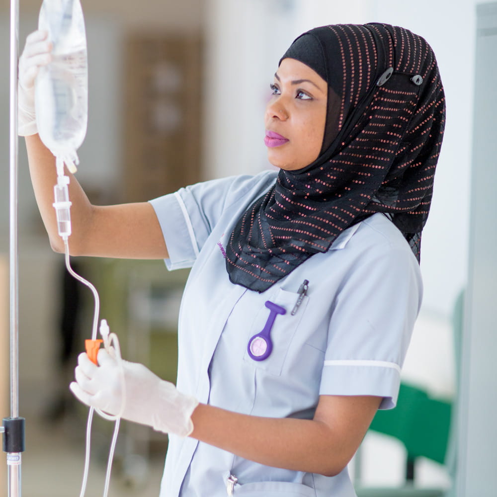 Female nursing student wearing a uniform and a head scarf using healthcare equipment
