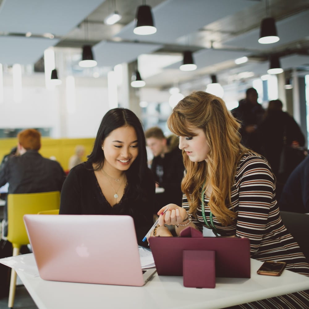 two girls looking at a laptop