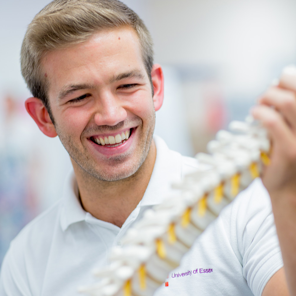 Health and Human Sciences student training with plastic skeleton