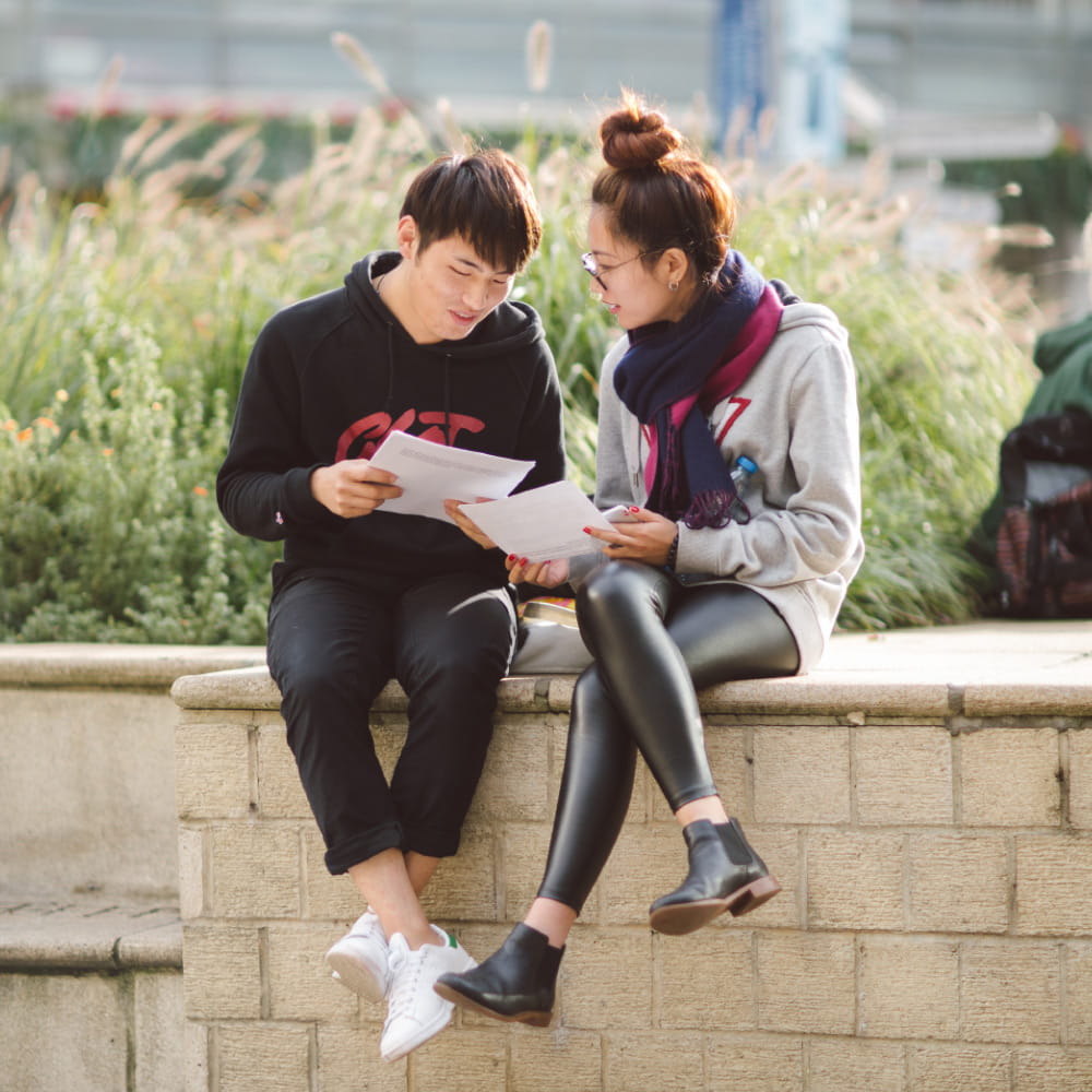 Image of two Asian students sitting in Square 4 at the Colchester Campus