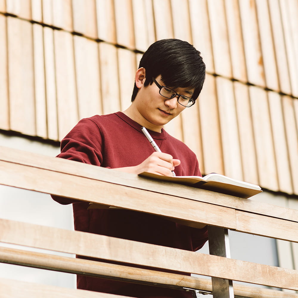 Student writing in a notebook