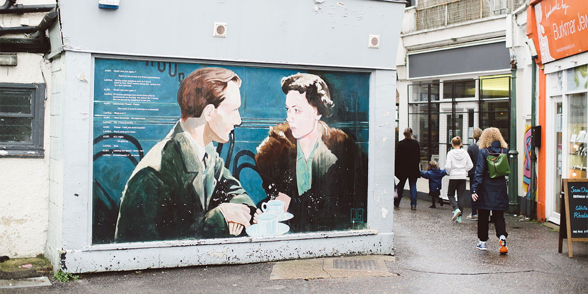 Painting of a woman and man in a cafe on a shop shutter