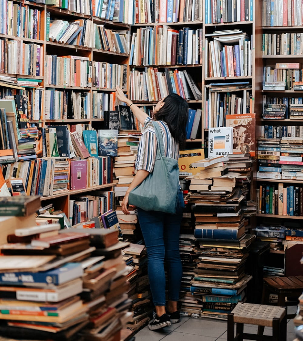 Person reaching up in a library corner