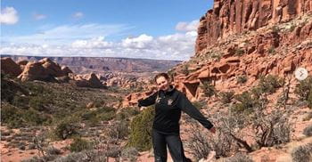 A student stands in a mountainous area in USA