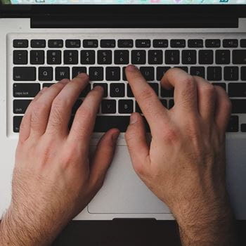 Male hands typing on a laptop