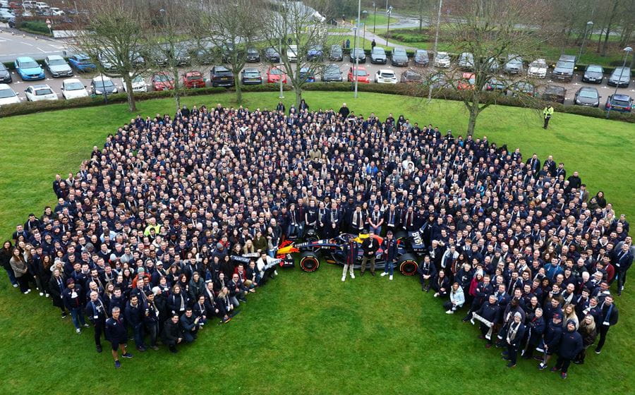 Martin Galpin with his team, a large crowd of people, standing on a grass field surrounded by a parking lot