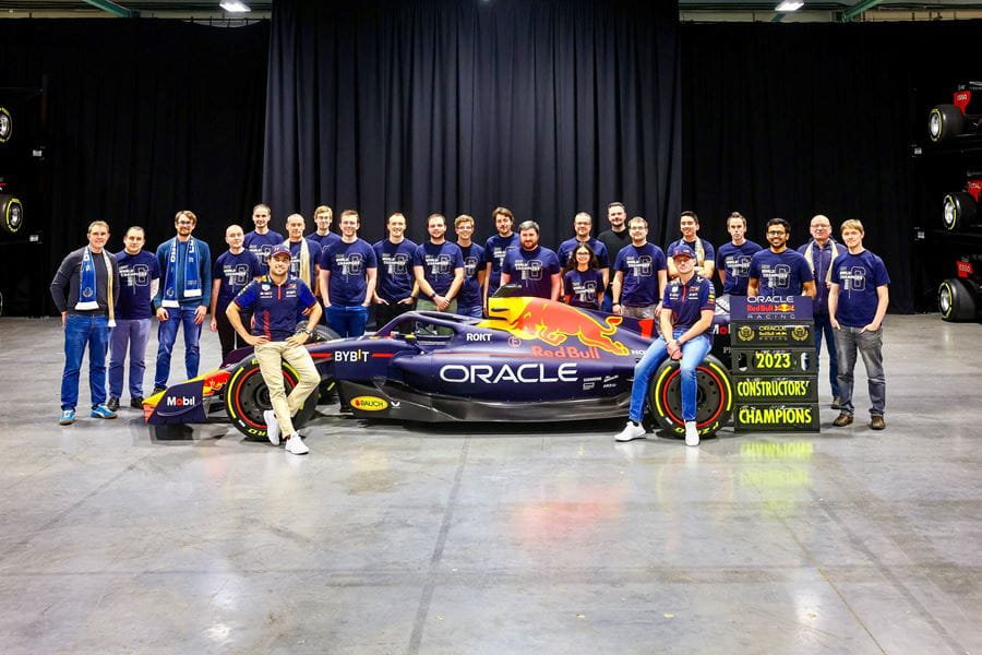 Martin Gulpin with the red bull team standing in a presentation hall in front of a sports car