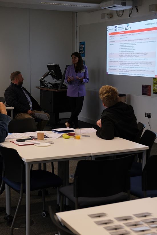People gathered at the table attending a workshop delivered by Dr Marta)