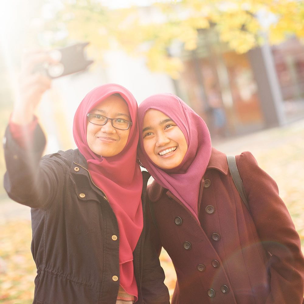 Two students taking a selfie with a mobile phone