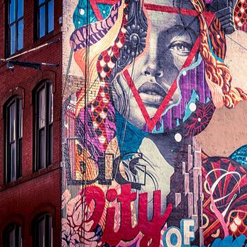 Colourful mural of a person on the side of building