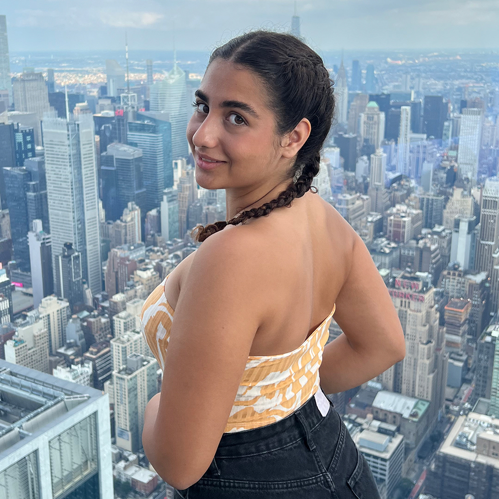 Maria Lousia Stouppa smiles in front of a city skyline.