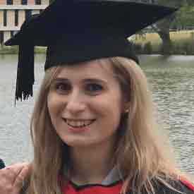 Samantha Woodward, smiling and wearing a graduation mortar board and gown