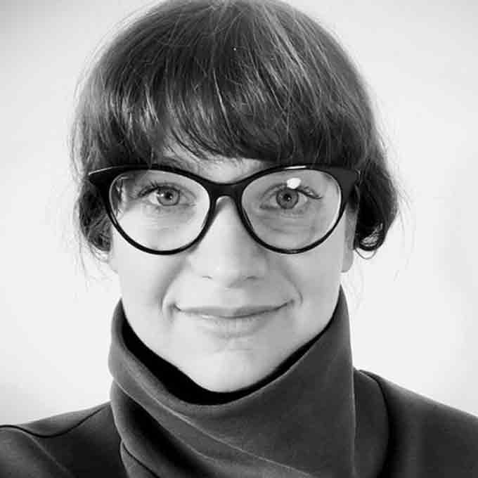 Solange Gulizzi, wearing glasses and a roll neck top