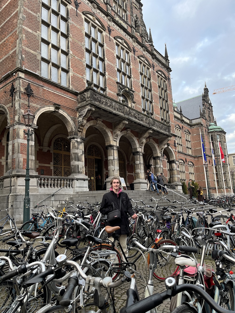 student Corey stood next to loads of bikes parked outside University building in Netherlands