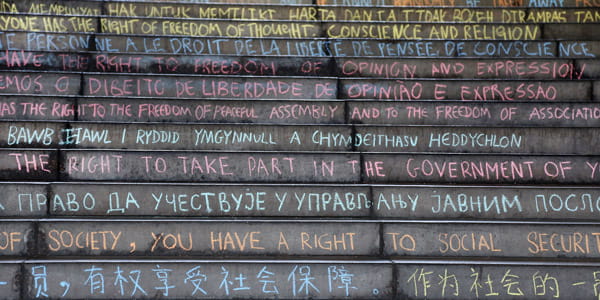 Steps between Squares 3 and 4 with the Human Rights declaration written in multiple languages in chalk