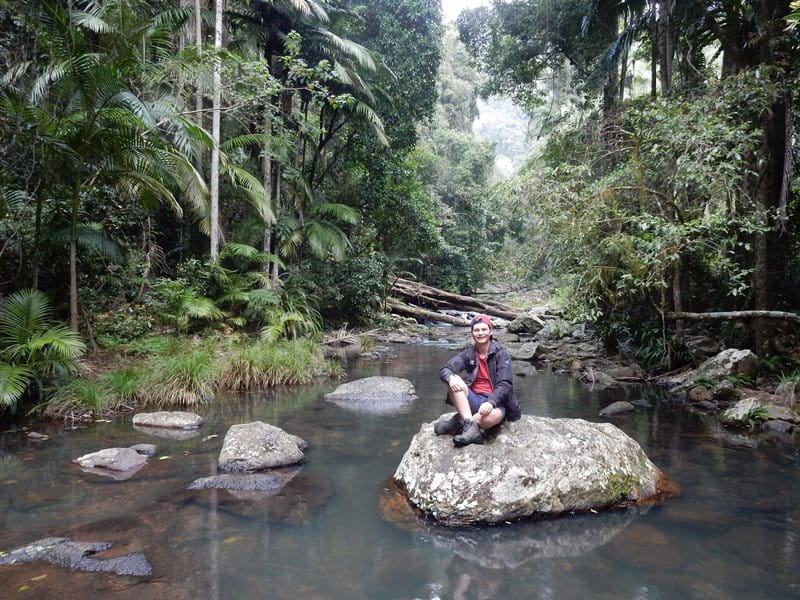 Perry James sat on a rock in the middle of a jungle river on a year abroad