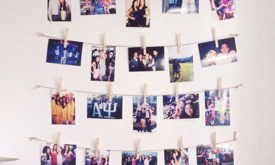 Photos attached to lines of string on a wall