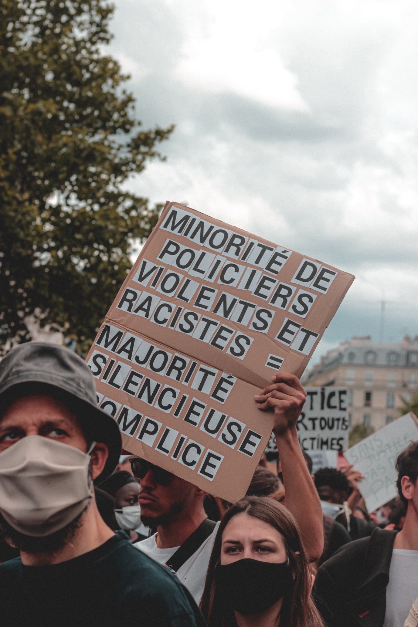 protest placard reading (in French) Minority of police violent and racist equals majority of police are silent and complicit