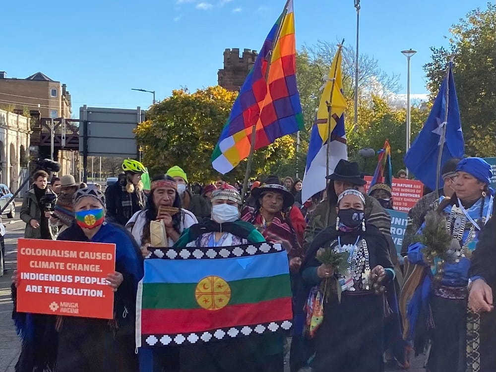 Photo of demonstration at COP26 of transnational activists deiverning 30 indigenous representatives of hte Minga Indigena to gates of Blue zone