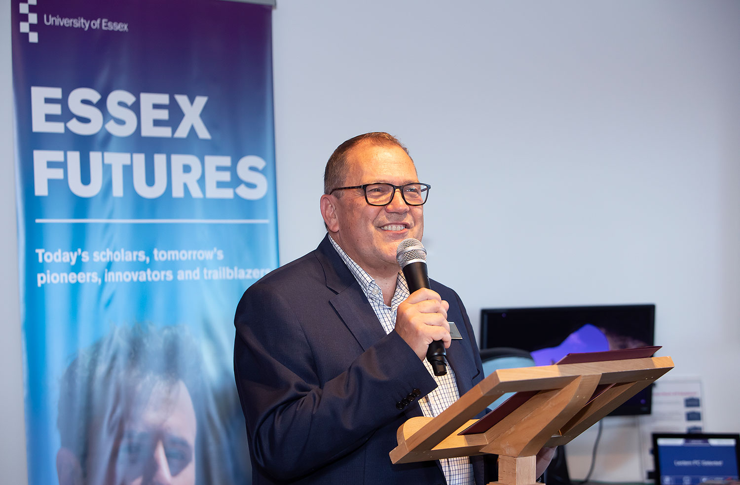 Bryn Morris speaking in front of a banner for Essex Futures.