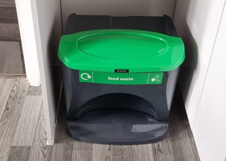 A food waste bin under a kitchen worktop in accommodation.