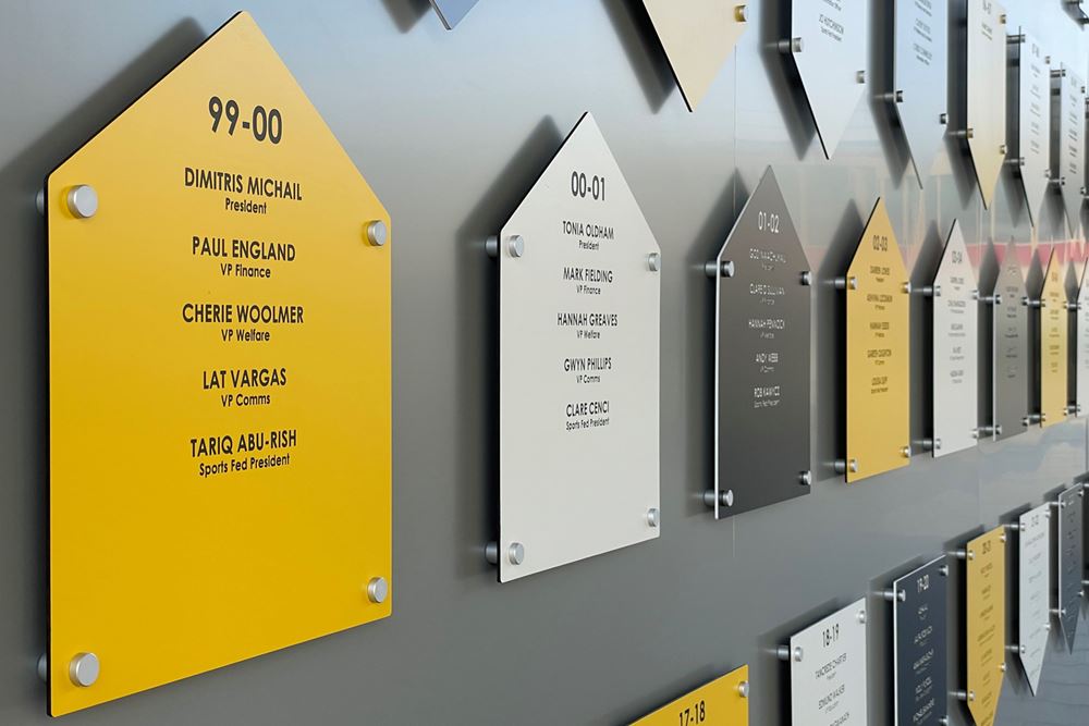 Plaques on our Wall of Fame arranged in date order. Each one shows an academic year and the names and posts of Students' Union leaders in that year.