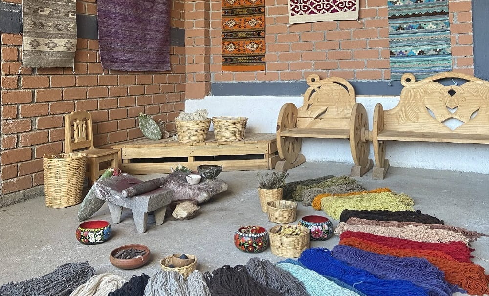 A room displaying Mexican handmade rugs and the 100%  natural dyed fabric used the make them
