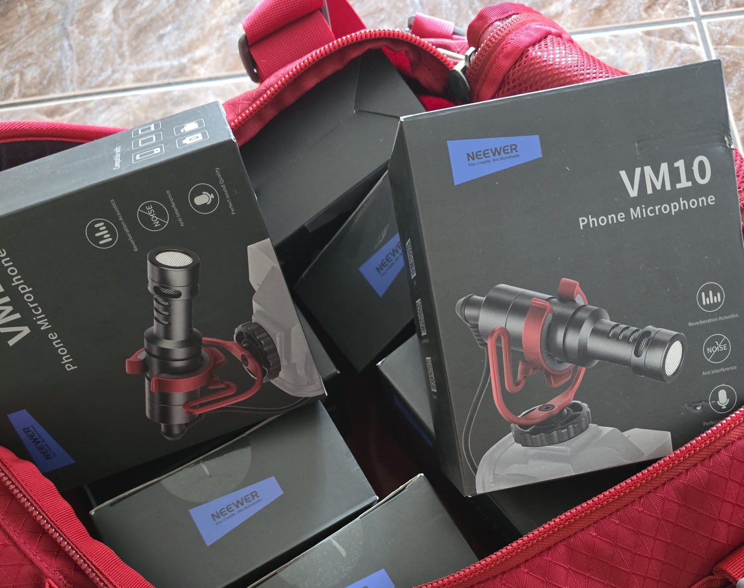 A red bag, open to reveal boxes of phone microphones.