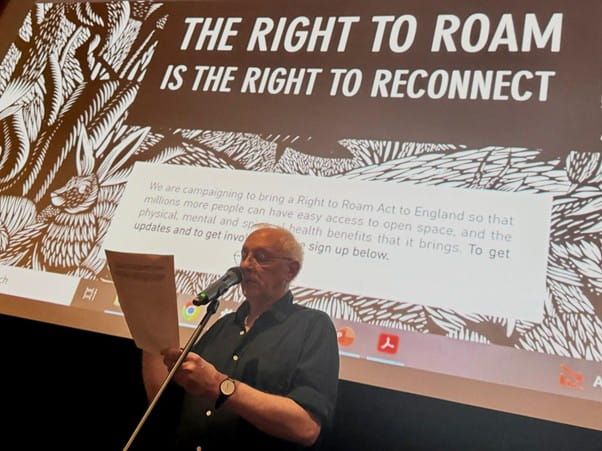 Colin Samson giving a presentation on "The right to roam", with the talk title projected onto a screen behind him.
