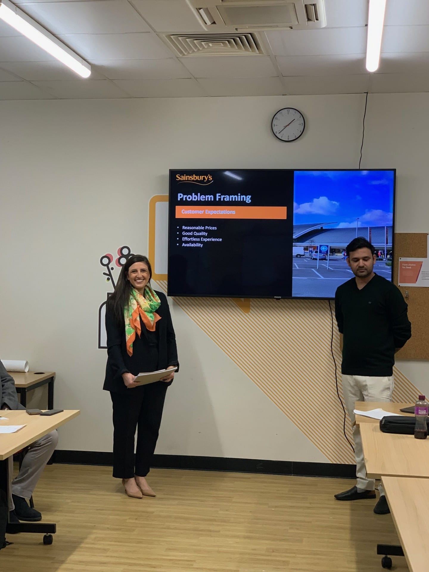 two people standing in front of a tv screen which reads 'problem framing'