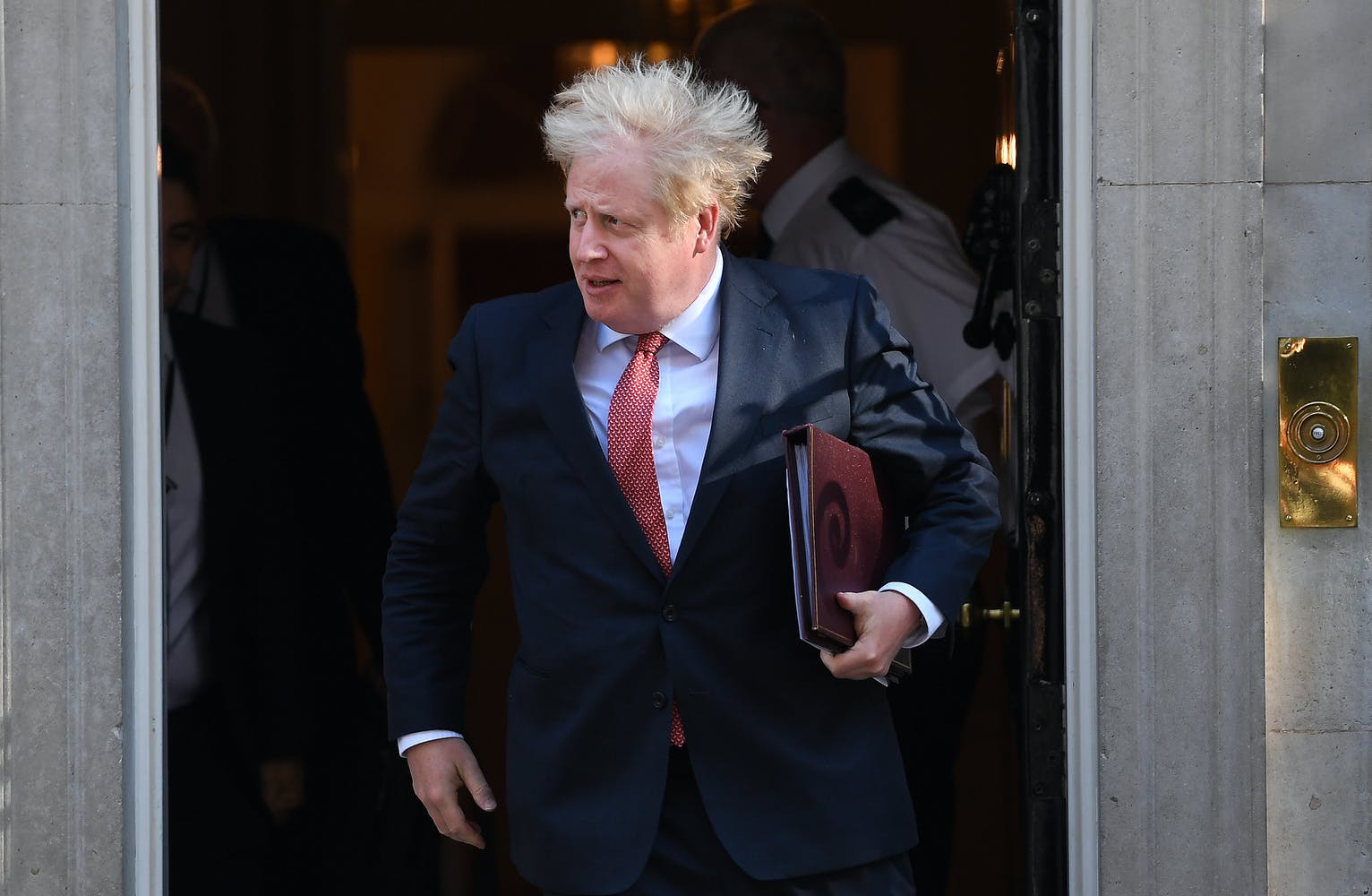 Boris Johnson walking out of 10 Downing Street on a windy day