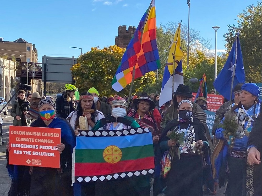 Photo of demonstration at COP26 of transnational activists deiverning 30 indigenous representatives of hte Minga Indigena to gates of Blue zone