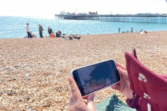 Watching videos on your phone down the beach in the sunshine