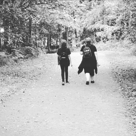 Two people walking through a woodland