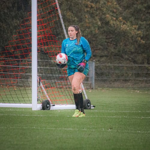 University of Essex womens performance football goalkeeper Hayley Jacobson mid game in front of a goal on grass pitches