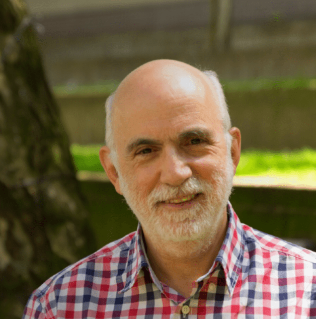 Head and shoulders photo of Professor Renos Papadopoulos, with grass visible in the background.