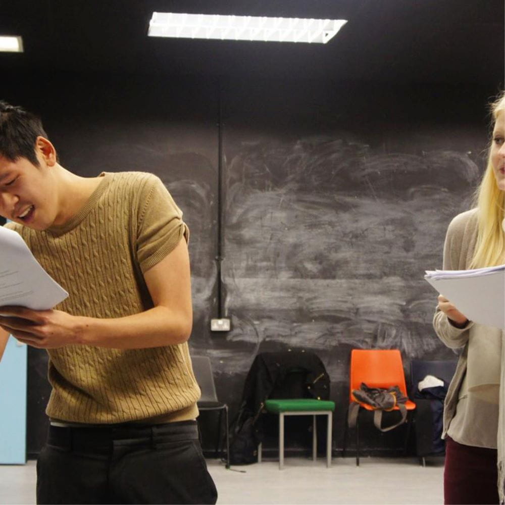 Drama students rehearsing with script