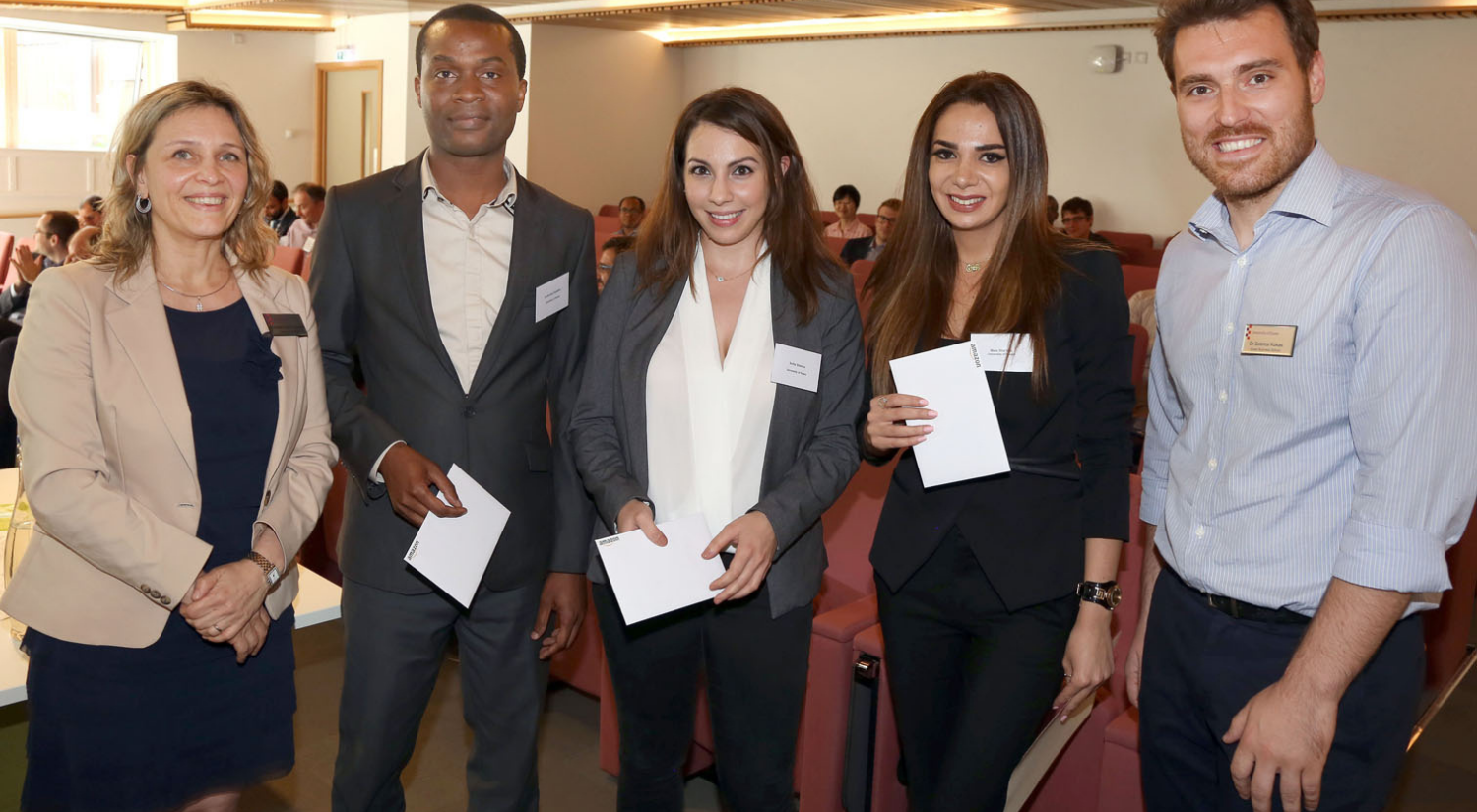 A group photo of five academics in a lecture hall