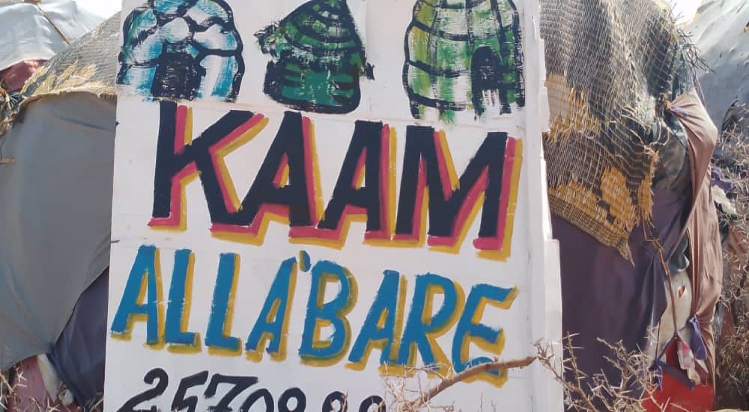 A picture of a poster with house drawings and the phrase 'Kaam Alla'Bare'