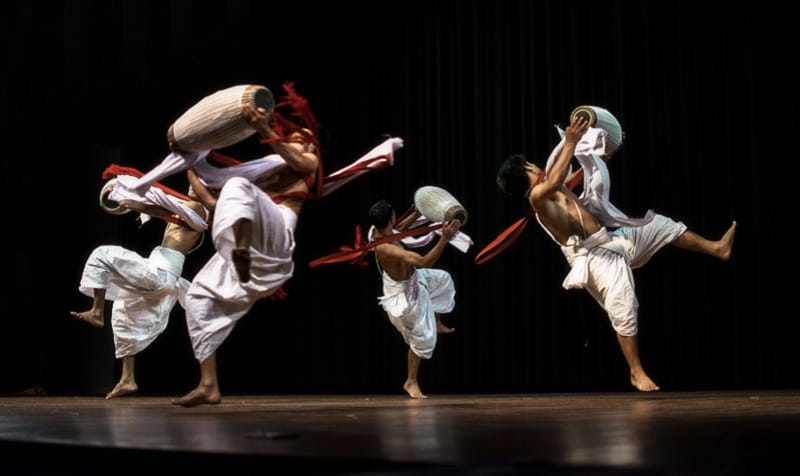 group of men holding drums performing on stage