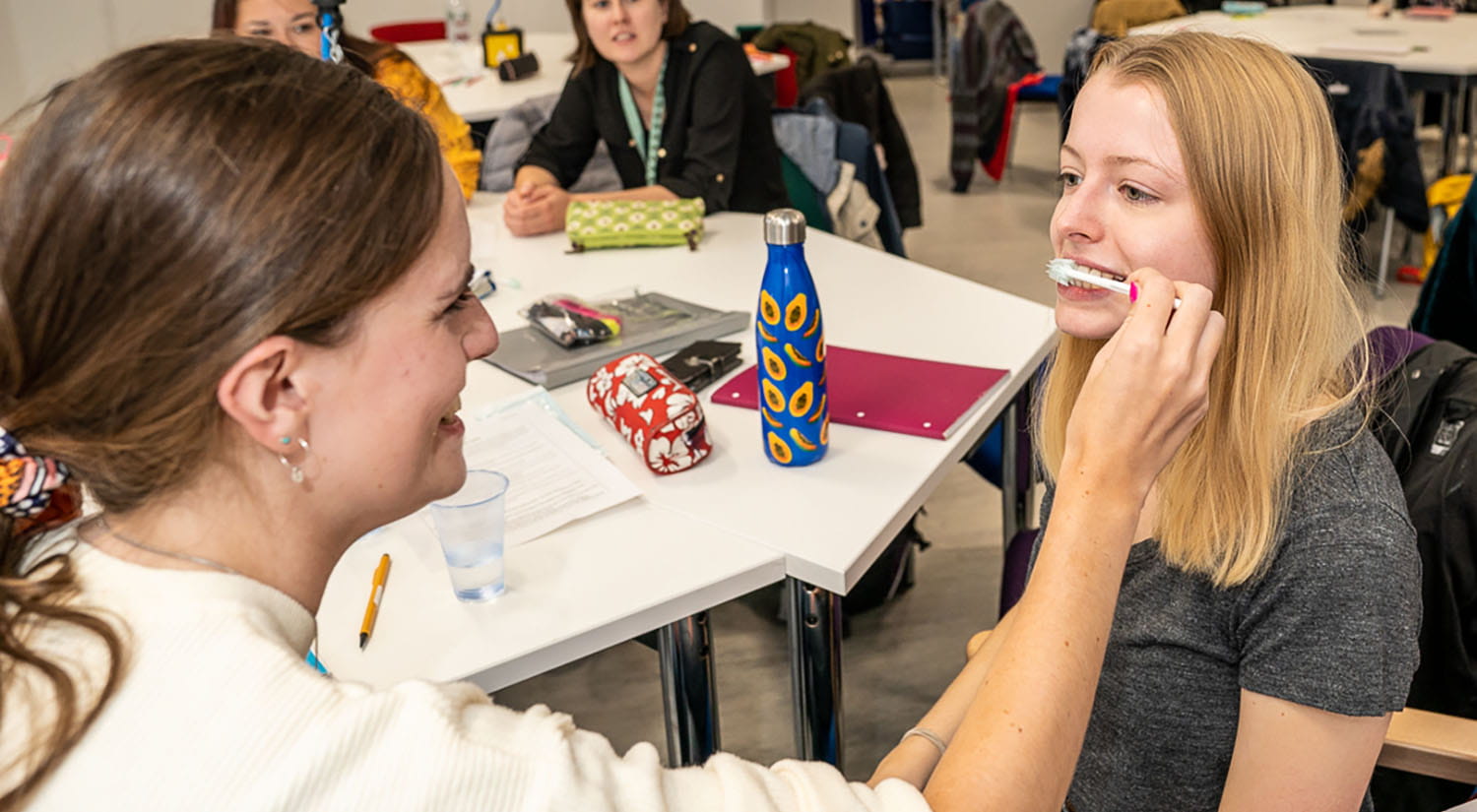 SLT students learning about teaching oral hygiene by cleaning each other's teeth