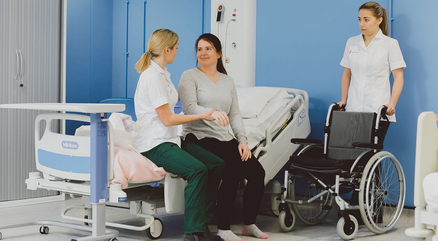 Occupational Therapy students practising supporting a patient to get out of bed