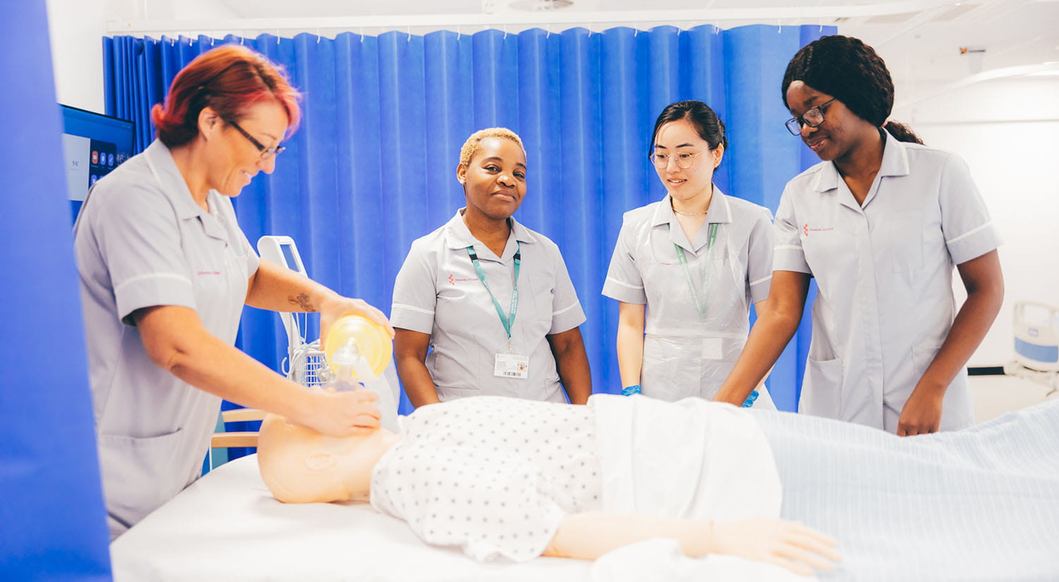 Nursing students practising patient care on a training manikin